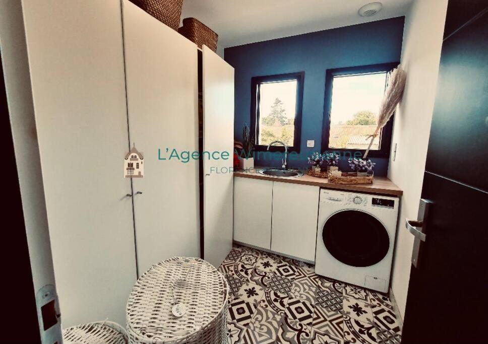a laundry room with a washing machine and a sink at Magnifique villa avec jaccuzi in Wimille