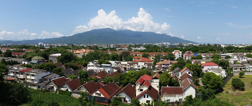 a city with houses and a mountain in the background at Penthouse Galare Thong Tower in Chiang Mai