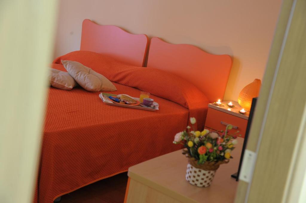 マンドゥーリアにあるB&B Abitazione Sandraのベッドルーム1室(オレンジのベッド1台、食料トレイ付)