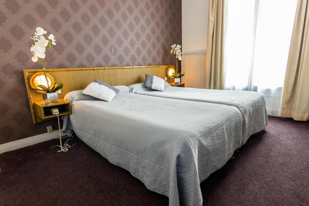 a hotel room with two beds and a window at Abc Champerret in Levallois-Perret
