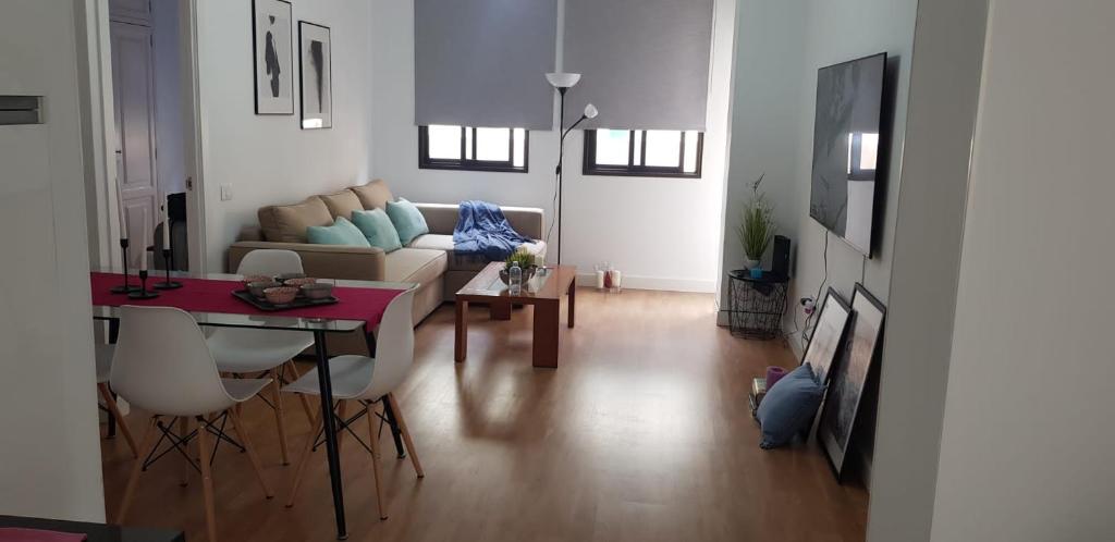 een woonkamer met een bank en een tafel bij Apartamento cerca de la Playa de Las Canteras in Las Palmas de Gran Canaria