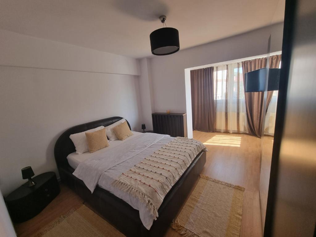 een slaapkamer met een bed en een groot raam bij Clau Home in Hunedoara