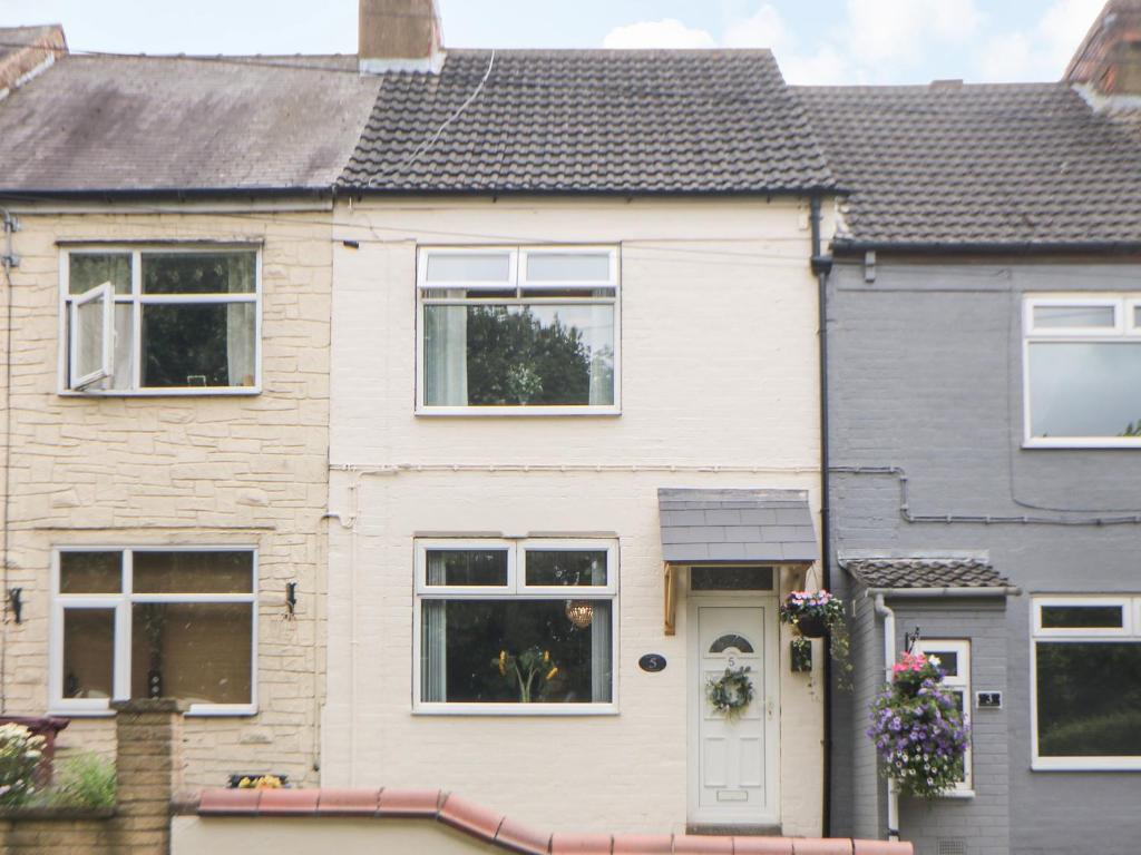 a house with a white door and windows at Appletree Cottage in Chesterfield