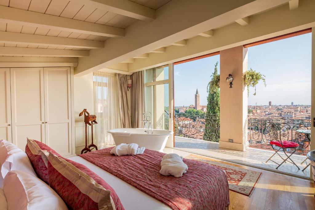 una camera da letto con vasca e ampia finestra di Relais Colle San Pietro a Verona