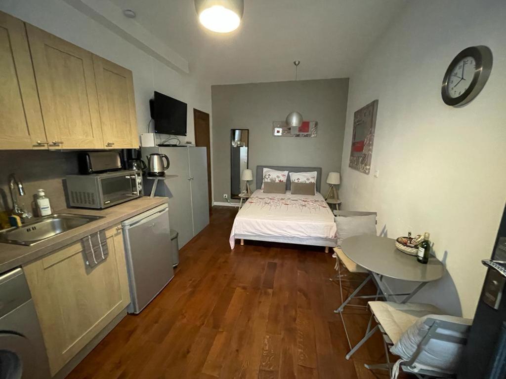 - une cuisine avec un lit et une table dans une chambre dans l'établissement Studio Saint-Placide, à Paris