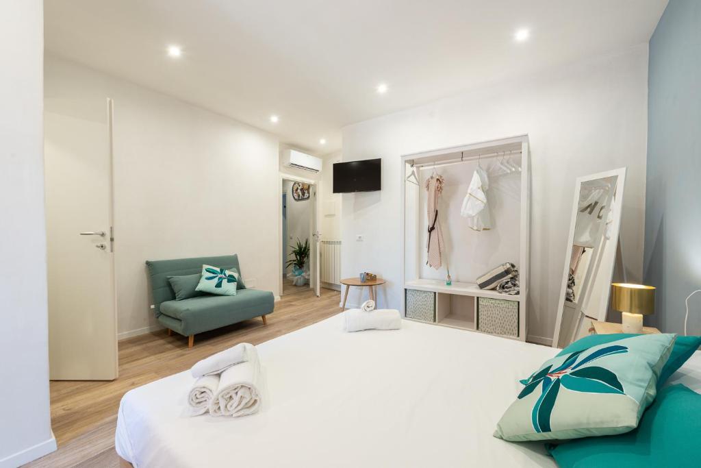 sypialnia z dużym białym łóżkiem i krzesłem w obiekcie B&B Interno12 w mieście Follonica