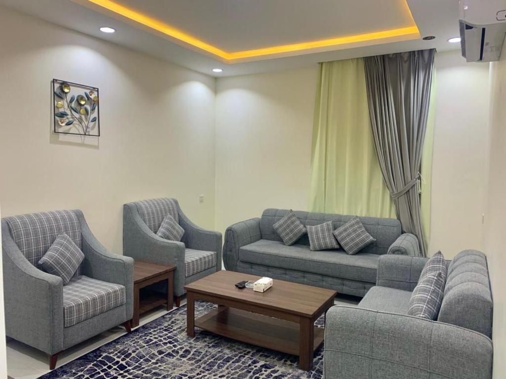 a living room with three couches and a coffee table at برادايز للاجنحة المخدومة in Khamis Mushayt