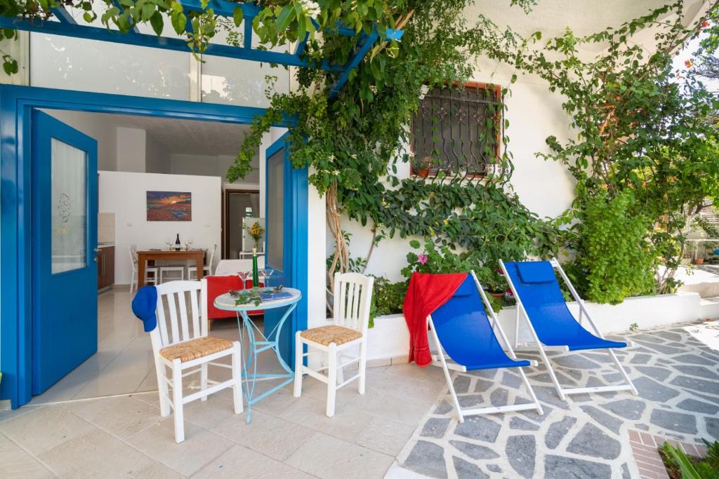 eine Terrasse mit Stühlen und einem Tisch und einer blauen Tür in der Unterkunft Ibiscus and Lily Apartments in Rhodos (Stadt)