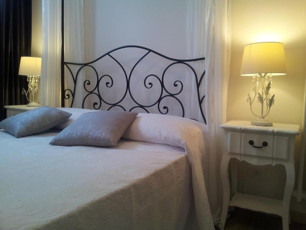 een slaapkamer met een bed en 2 tafels met lampen bij Dear Venice Bed & Breakfast in Marghera