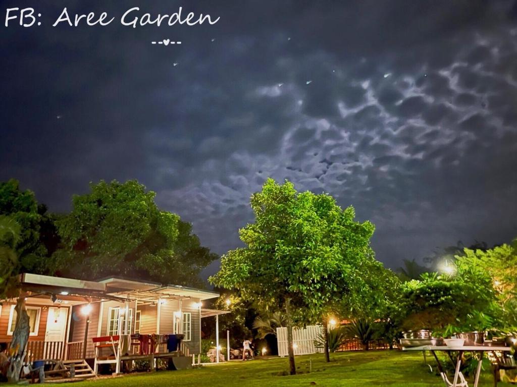 un cielo nublado sobre una casa en un patio en Aree Garden Home Private Homestay by the Waterfall Chantaburi - บ้านสวนพลิ้วอารี ริมธารน้ำตกพลิ้ว จันทบุรี, 
