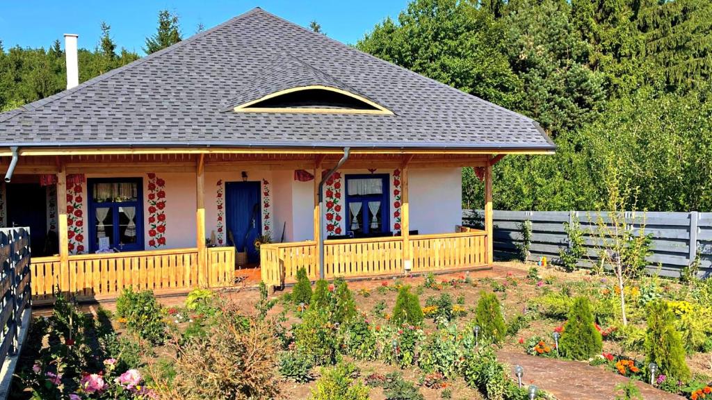 a small house with a porch and blue doors at Pensiunea „Căsuța cu maci” in Iaşi