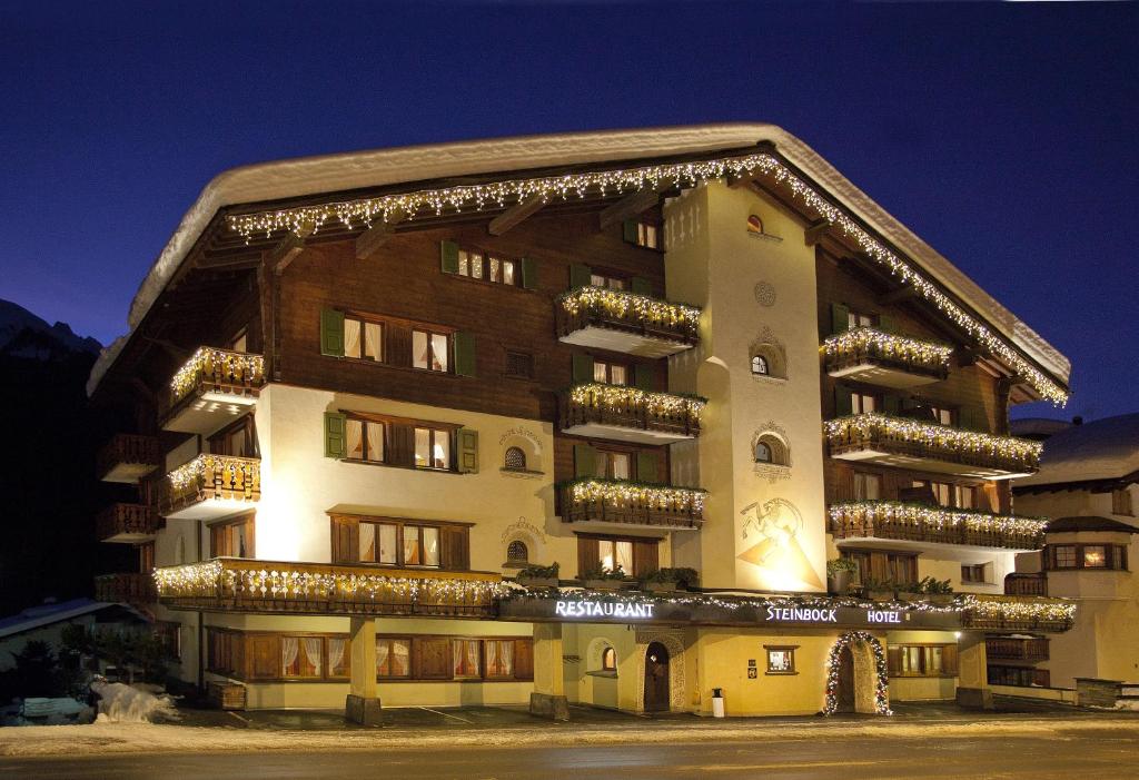 a large building with christmas lights on it at Hotel Steinbock in Klosters