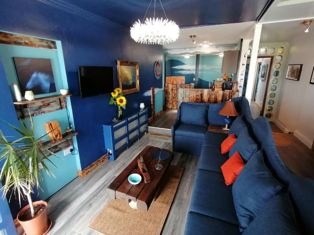 een blauwe woonkamer met een blauwe bank bij Mourne Mountain Art Apartments in Newcastle