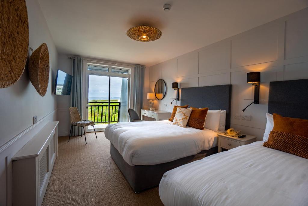 a hotel room with two beds and a balcony at The Cliff House Hotel in Ballybunion