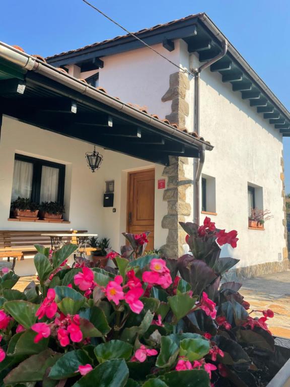 ein Haus mit rosa Blumen davor in der Unterkunft Casa de Campo in Potes