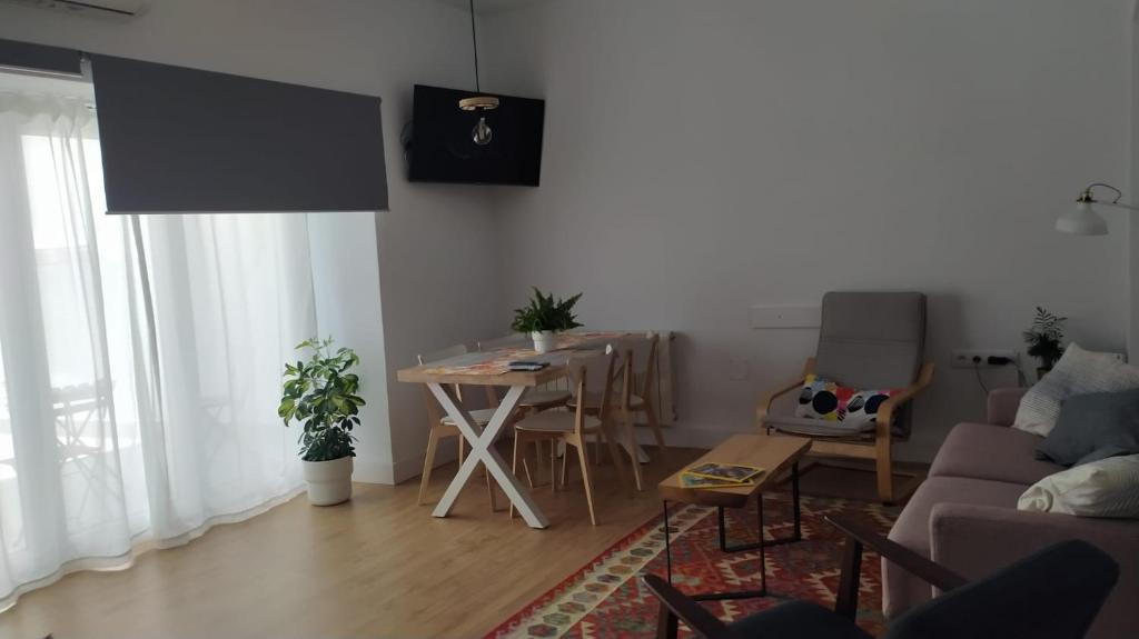 Iulia Emérita Centro في ماردة: غرفة معيشة مع طاولة وغرفة طعام