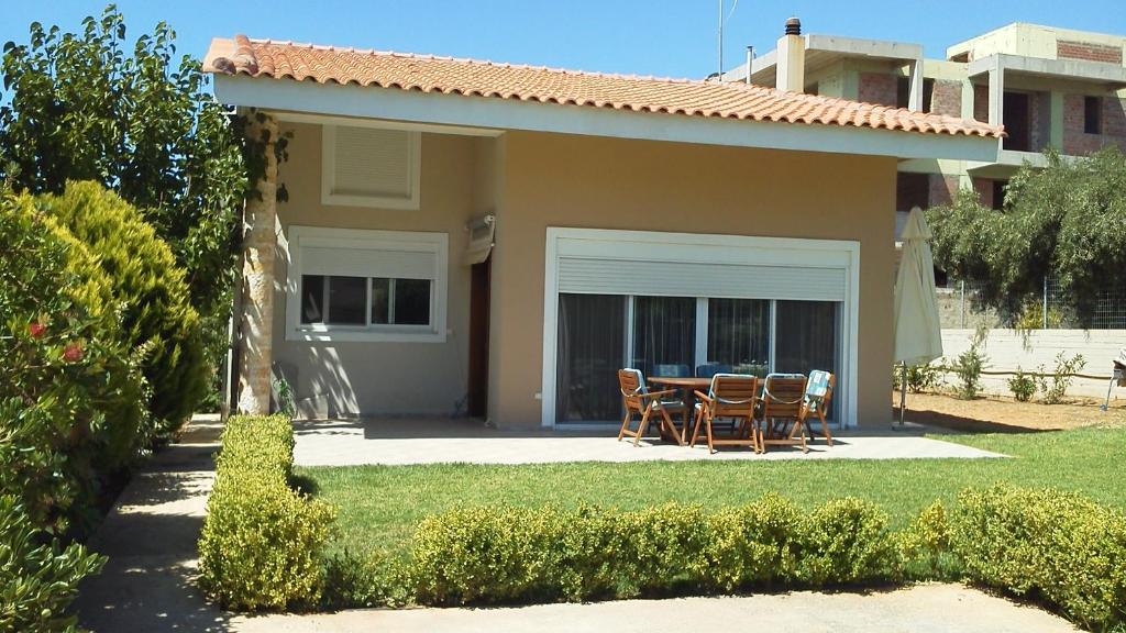 a house with a table and chairs in the yard at Villa K in Áyios Konstandínos