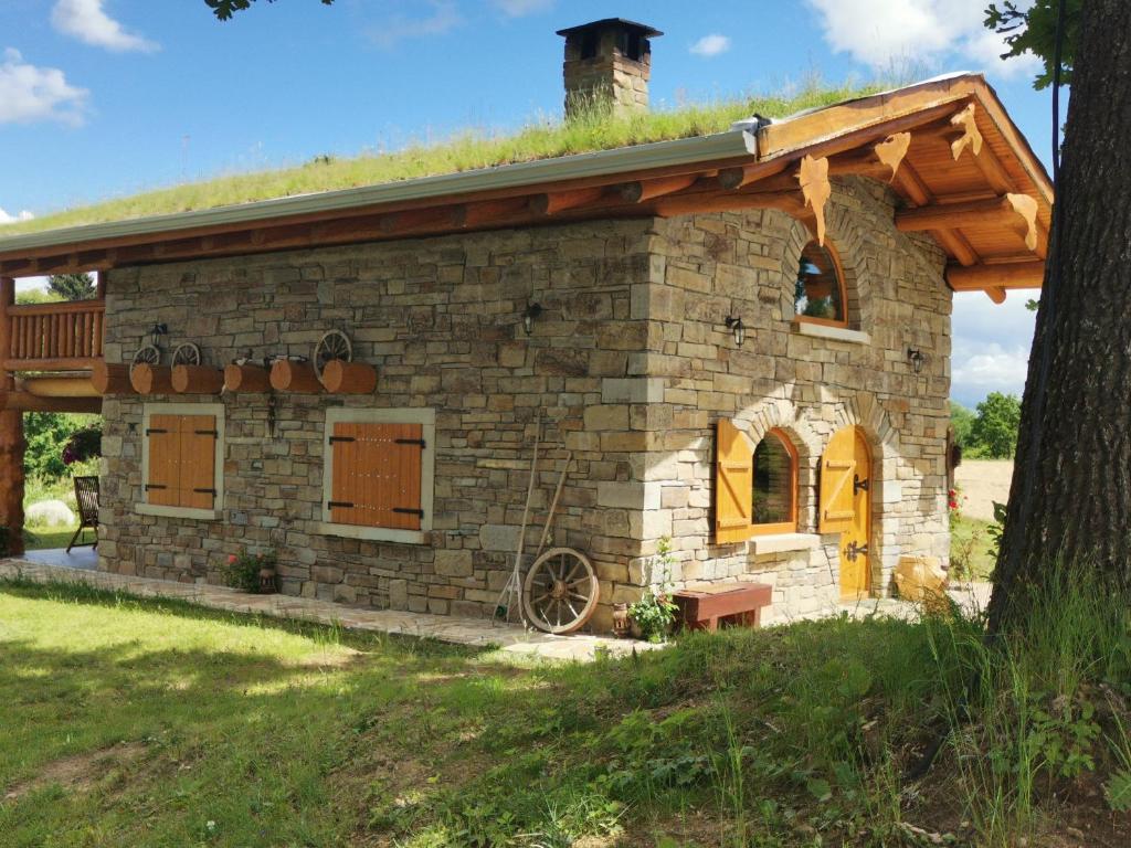 uma pequena casa de pedra com telhado de relva em Casa de Piatra, de la Mara em Deseşti