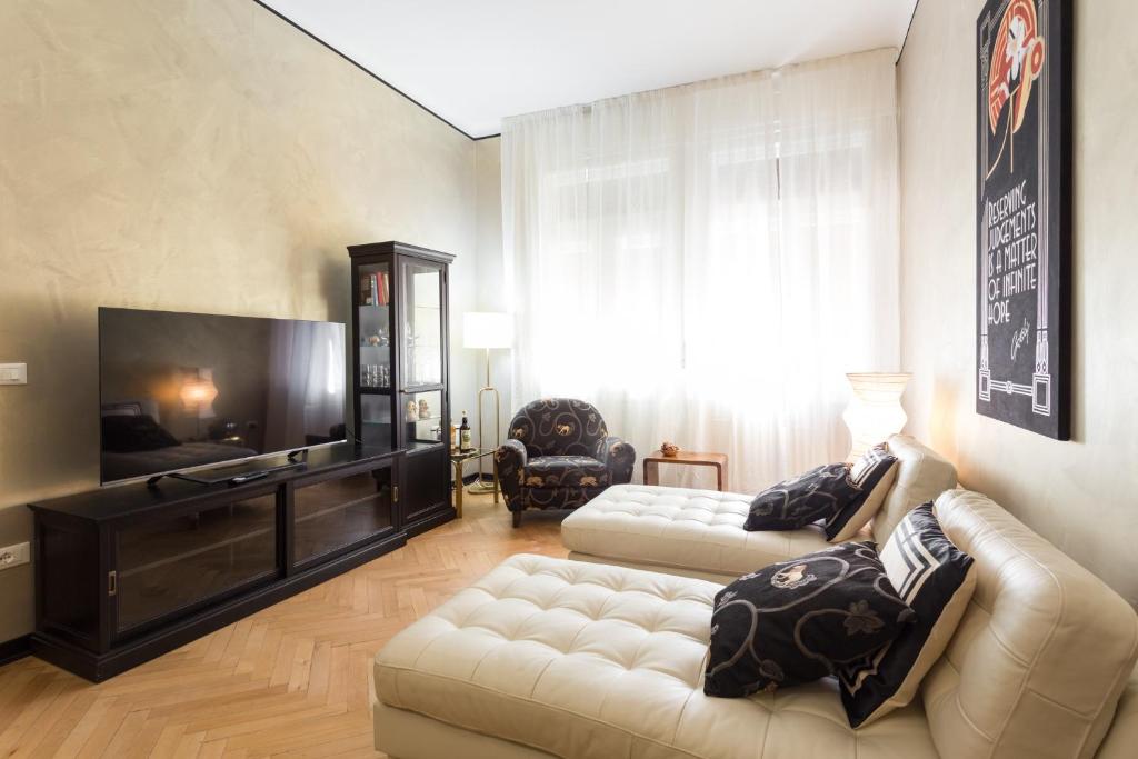 sala de estar con 2 sofás y TV de pantalla plana en La casa di Gatsby lusso in pieno centro con parcheggio, en Gorizia