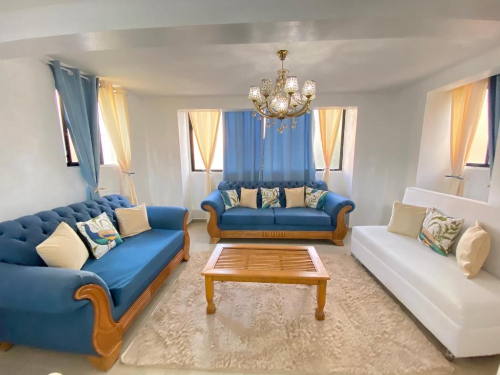 a living room with two blue couches and a chandelier at 8 Santiago Monumental Area Cozy and lovely to enjoy 3 bedrooms Apart transportation 24 hours in Santiago de los Caballeros