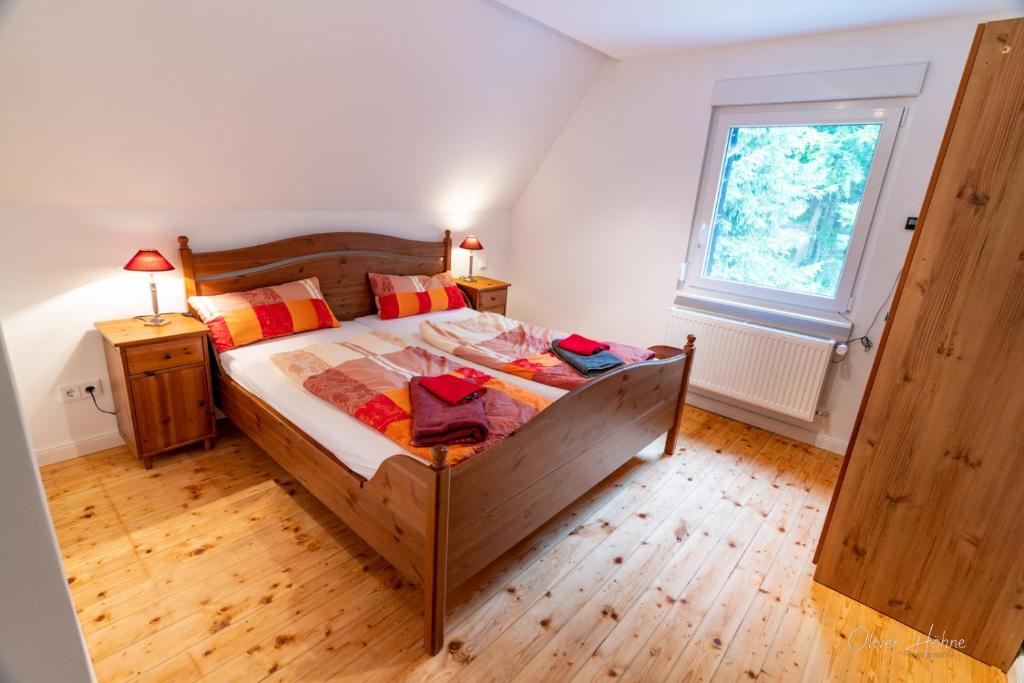 a bedroom with a wooden bed and a window at Ferienwohnung am Waldrand in Bad Laasphe