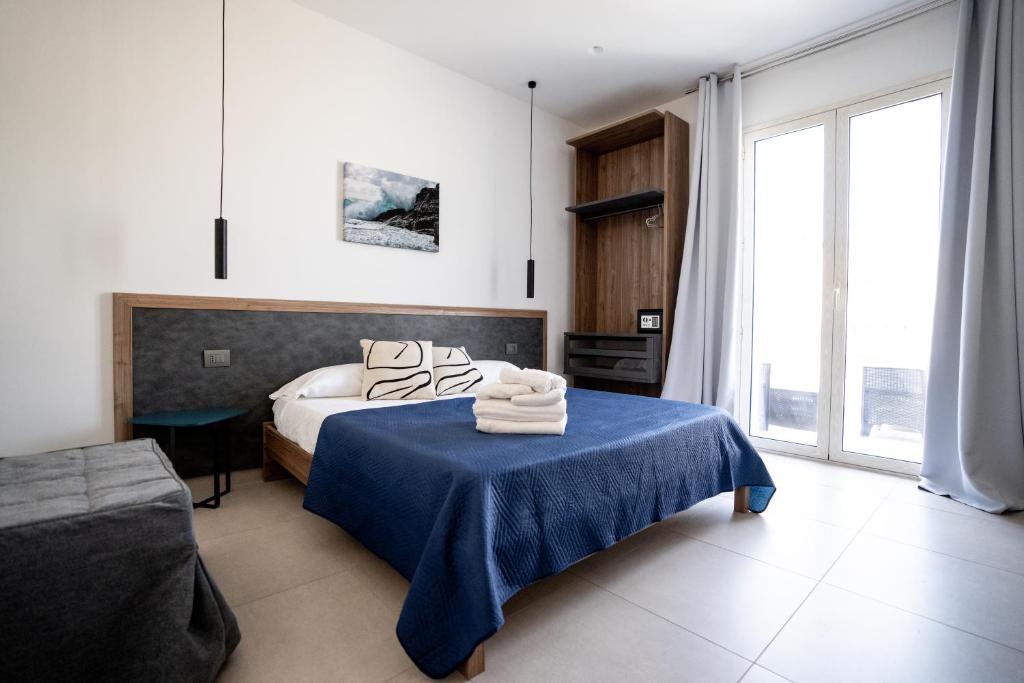 a bedroom with a bed and a table with towels on it at B&B il Colibrì in San Vito lo Capo