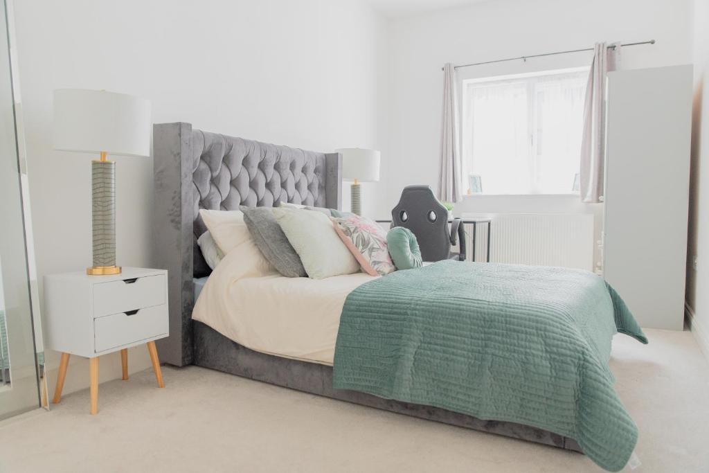 um quarto com uma cama grande e um cobertor verde em Portsmouth City Centre Modern Apartment - with Free Parking em Portsmouth