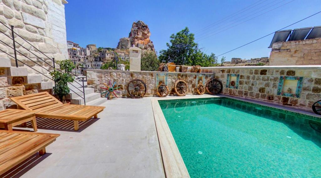 une villa avec une piscine et deux bancs dans l'établissement Capp Royal Cave HOTEL, à Ürgüp