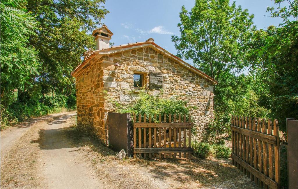 uma antiga casa de pedra com um portão e uma cerca em Stunning Home In Villagrande Di Monteco With Kitchen 