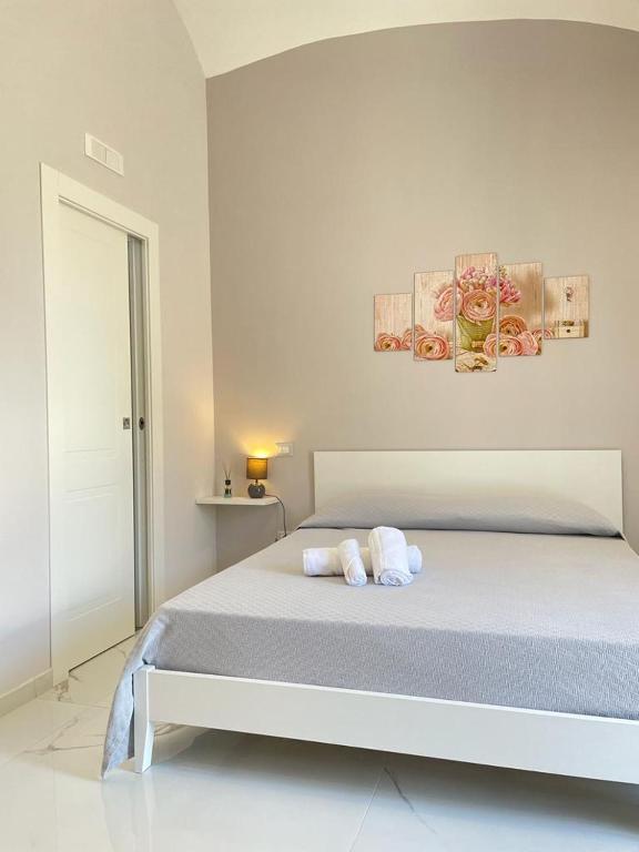 a white bedroom with a bed with towels on it at Sole apartments in Sarno