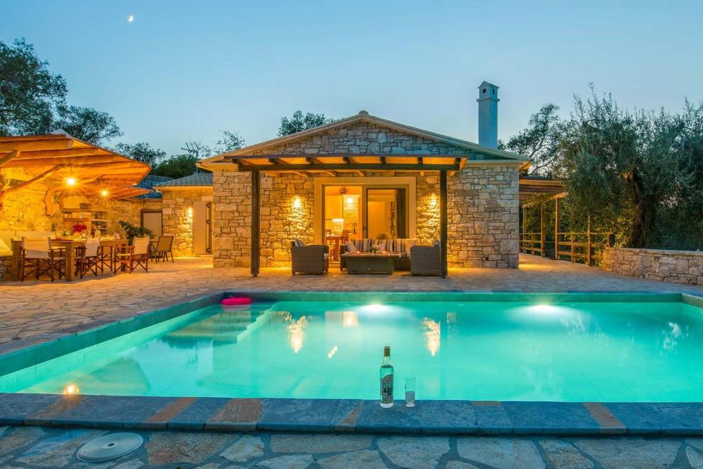 a swimming pool in front of a house at Aristea Villa by PaxosRetreats in Gaios