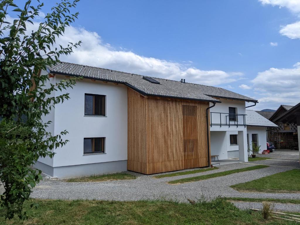 una casa con una puerta de madera en un lado en Klančarjeva domačija - Spacious countryside apartment on an eco farm, 