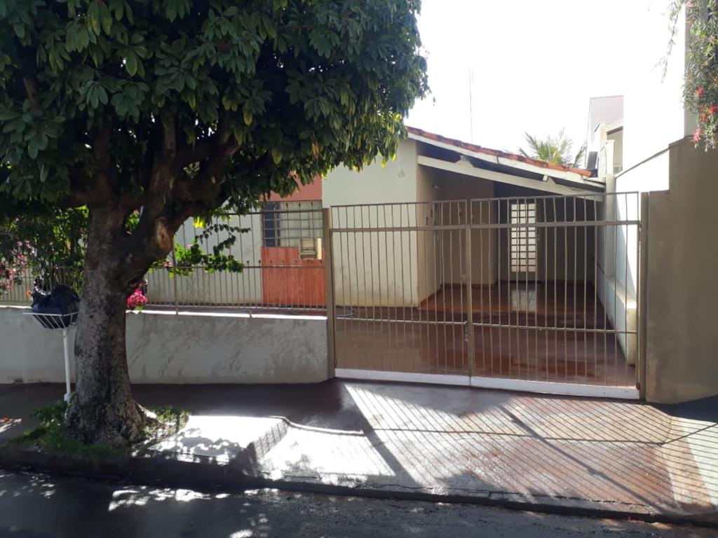 a fence in front of a house with a tree at Casa em Olímpia in Olímpia