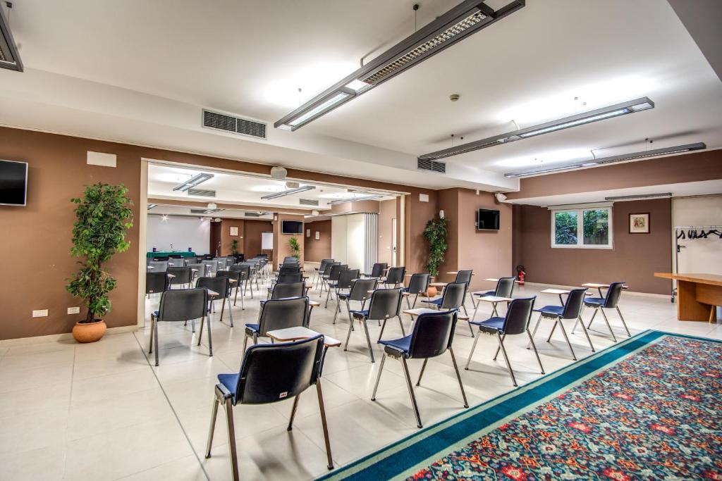duży pokój z krzesłami i stołami oraz podium w obiekcie Hotel Della Rotonda w mieście Saronno