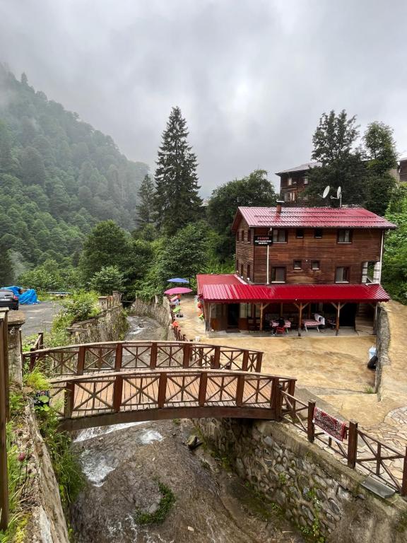 a wooden bridge over a river in front of a building at FERAH BUTİK OTEL in Çamlıhemşin
