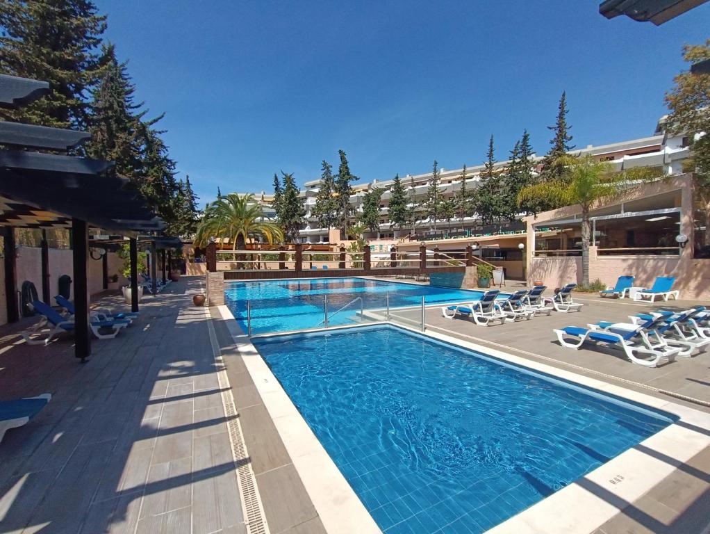 een zwembad in een resort met stoelen en een gebouw bij Blue & Yellow Penthouse with Terrace at Balaia Mar in Albufeira
