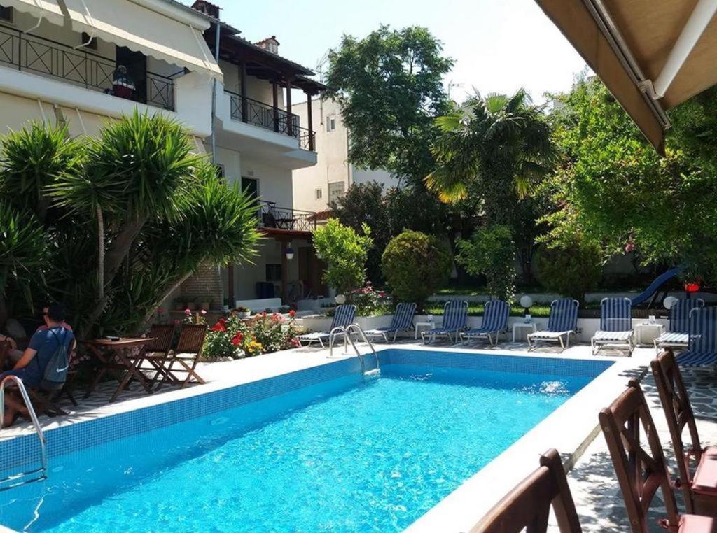 a pool at a hotel with chairs and a building at Epic Studios Kallithea in Kallithea Halkidikis
