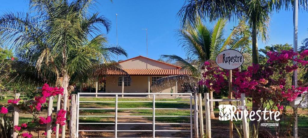 un panneau devant une maison plantée de palmiers dans l'établissement Sítio Rupestre - Peruaçu, à Januária