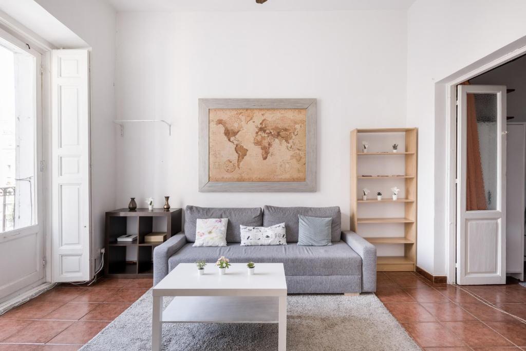 uma sala de estar com um sofá e uma mesa em Comfy 4 rooms apt in the heart of Chueca (Madrid center) em Madrid