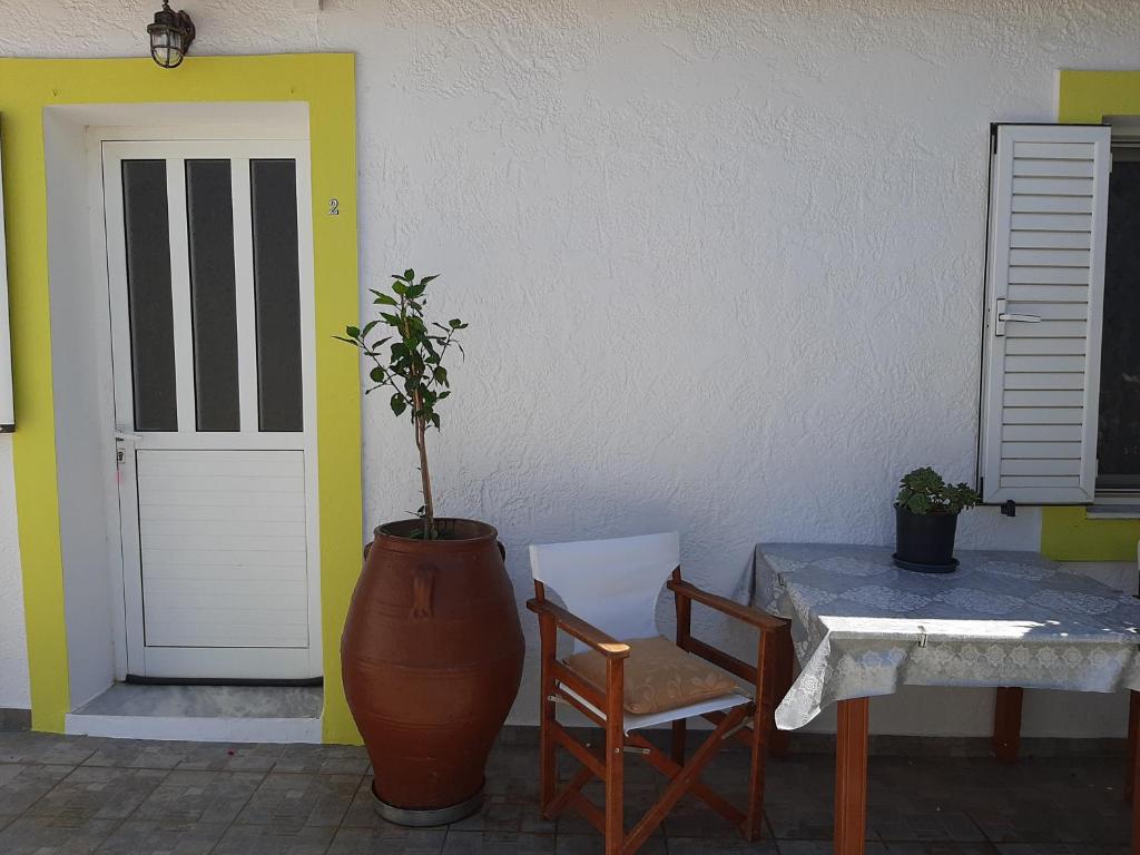a table and chairs and a vase next to a door at Lemon Garden 2 in Karídhion