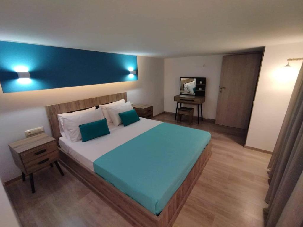 a bedroom with a large bed with a blue headboard at Plumbago Apartment in Theológos