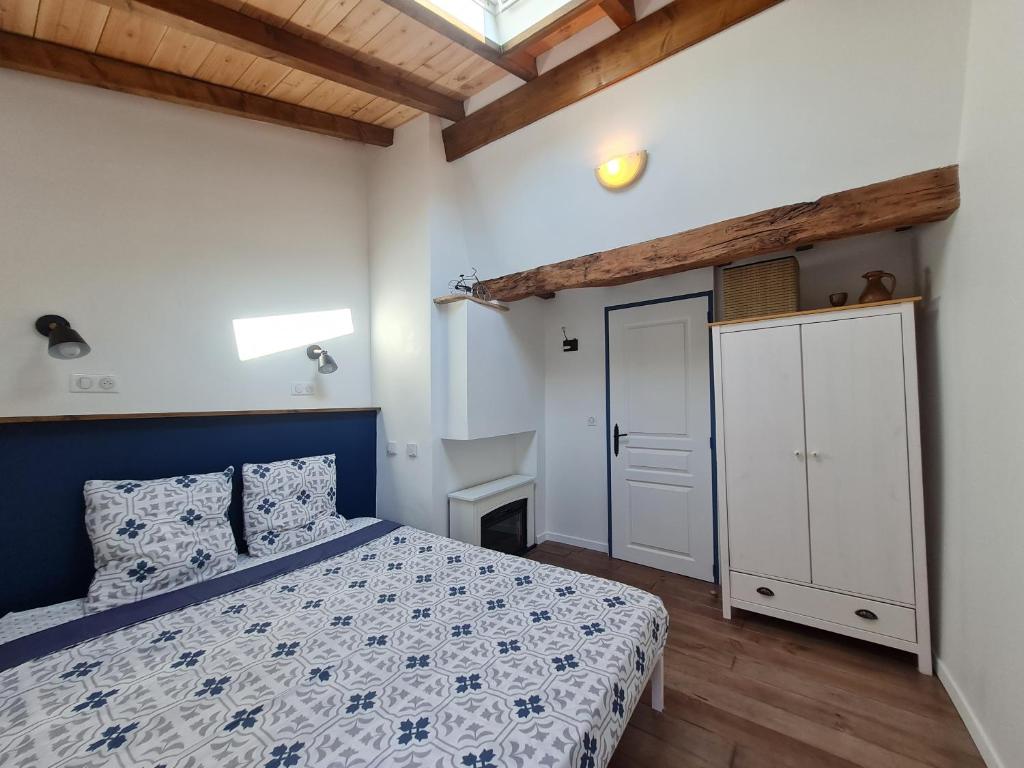 sypialnia z niebiesko-białym łóżkiem i drzwiami w obiekcie Triplex avec vue sur place du centre historique. w mieście Foix