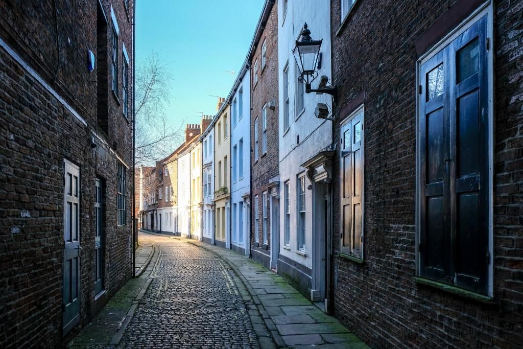 an empty alley in a city with brick buildings at Spirit of Prince Street Hull Old Town in Hull
