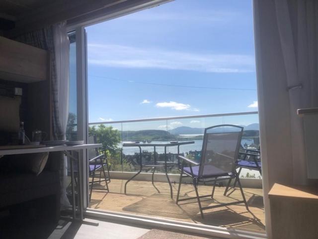 a view of a balcony with chairs and a table at Benvoulin Bothy - luxury pod with stunning views in Oban