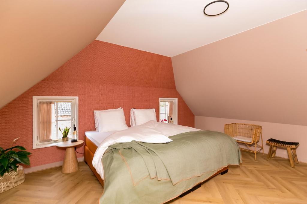 een slaapkamer met een groot bed op zolder bij Brinkzate - De Brink in Dwingeloo