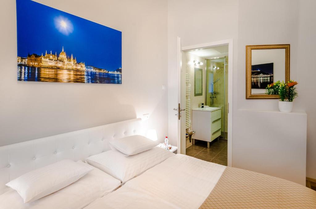 ein Schlafzimmer mit einem weißen Bett und einem Gemälde an der Wand in der Unterkunft Anabelle Bed and Budapest in Budapest