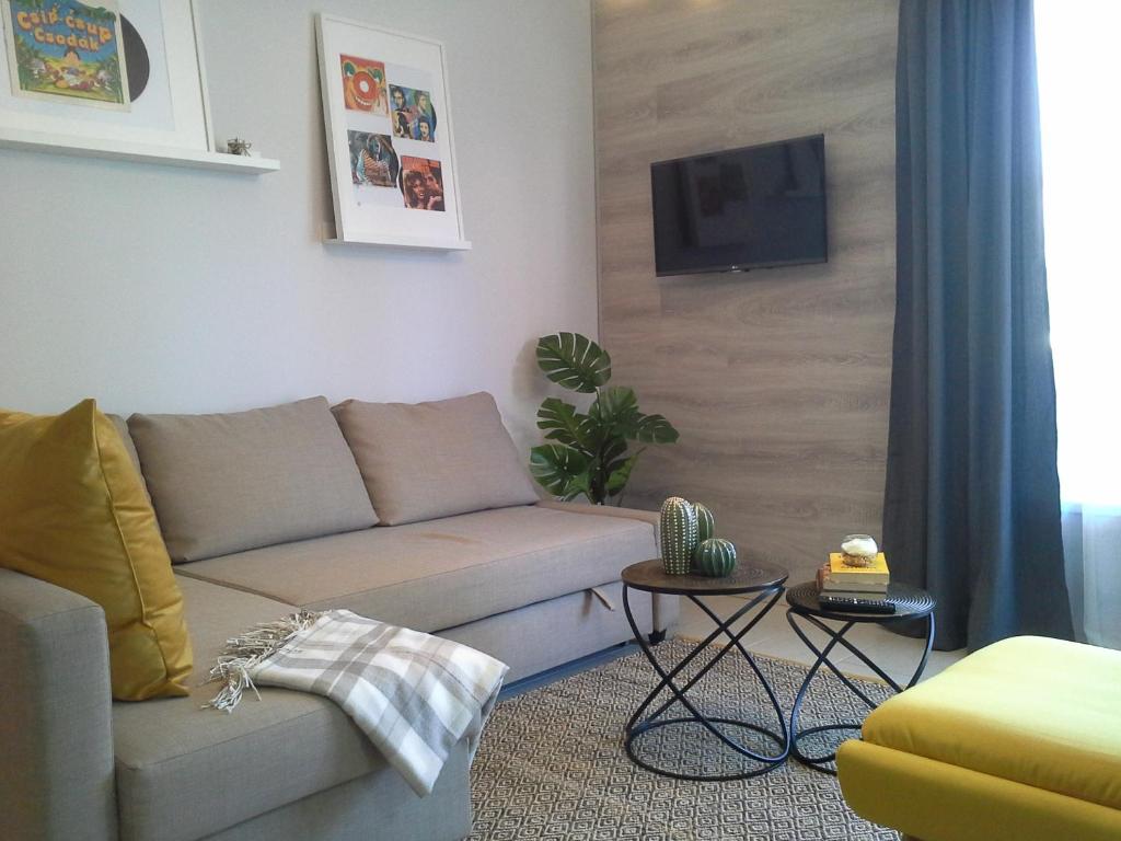 ein Wohnzimmer mit einem Sofa und einem Flachbild-TV in der Unterkunft Alexandra Apartment Hajdúszoboszló - Chic Flat in Hajdúszoboszló