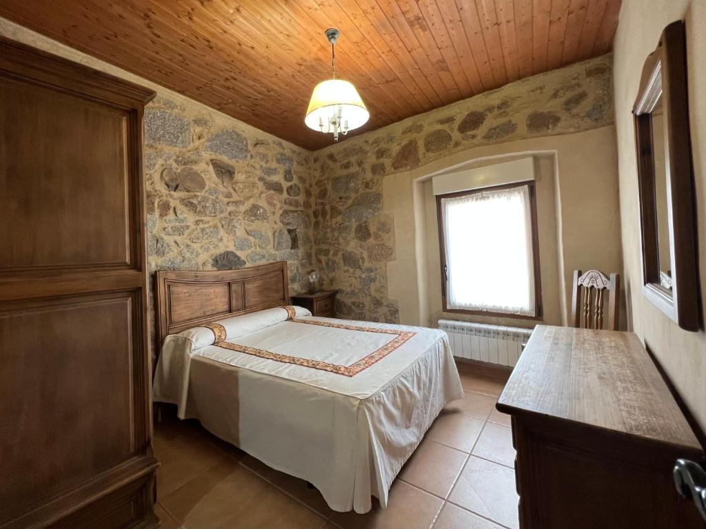 a bedroom with a bed and a window at Casa La Colmena Ávila in Ávila