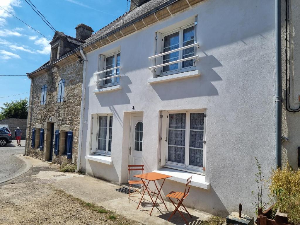 einen Tisch und Stühle außerhalb eines weißen Hauses in der Unterkunft Maison de ville Ty Richarzh, 2 chambres, 4 personnes in Plouharnel