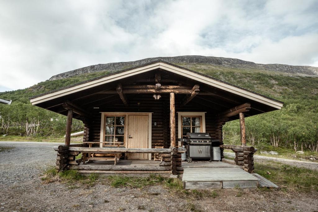 a log cabin with a stove in front of a mountain at Villa Pikku Saana in Kilpisjärvi